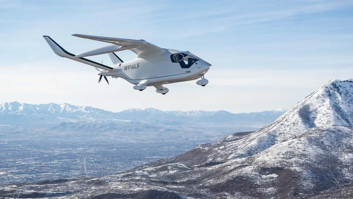 Electric aircraft flying over snowy mountains, demonstrating emerging zero-emission aviation technology.