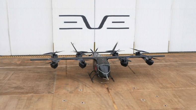 Electric air taxi prototype with multiple rotors displayed inside hangar