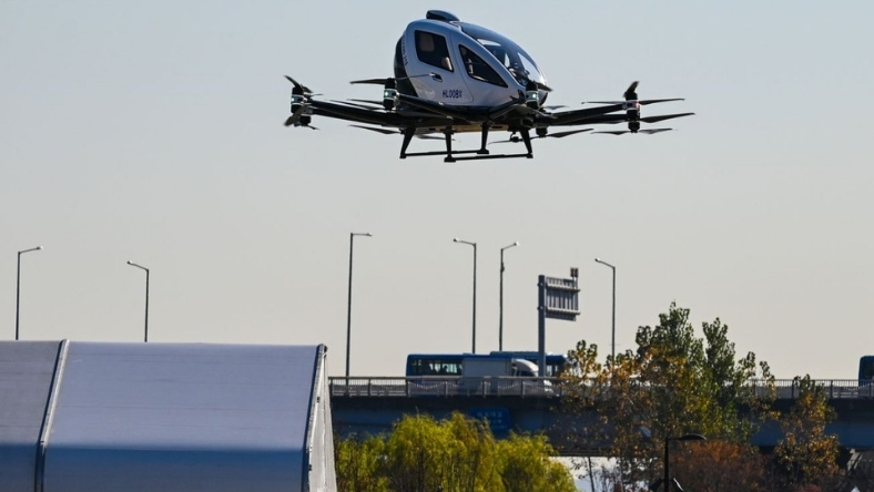 An electric vertical takeoff aircraft flying above a roadway